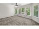 A bedroom with large windows and neutral carpet is bright and features a ceiling fan at 414 Dogwood Way, Canton, GA 30114