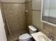 A compact bathroom with a stand up shower, tiled walls, a sink, and a toilet at 6956 Kimberland Gardens Ln, Lithonia, GA 30058