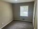 Cozy bedroom with neutral walls, carpet and view to the outdoors at 6956 Kimberland Gardens Ln, Lithonia, GA 30058