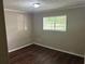Cozy bedroom featuring a window, wood paneling, and dark wood flooring at 6956 Kimberland Gardens Ln, Lithonia, GA 30058