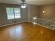 Bright living room with shining hardwood floors and white banister to upper level at 6956 Kimberland Gardens Ln, Lithonia, GA 30058