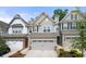 Exterior view of townhomes with attached garages, gray siding, and well-maintained landscaping at 1025 Cherryfield Run, Marietta, GA 30008
