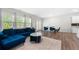 Open-concept living room featuring a plush blue sofa, modern rug, and a sunlit dining area at 1025 Cherryfield Run, Marietta, GA 30008