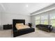 Spacious main bedroom featuring tray ceilings, a large bed with tufted headboard, and neutral decor at 1025 Cherryfield Run, Marietta, GA 30008