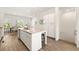 Open kitchen with a granite island, white cabinets, stainless steel appliances, and wood-look flooring at 1172 Edwin Ln, Sugar Hill, GA 30518