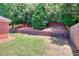 Backyard featuring a tiered retaining wall and a combination of grassy and mulched areas, blending beauty and utility at 2010 Hickory Station Cir, Snellville, GA 30078