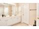 Bright bathroom featuring double sinks, white cabinetry, and a large mirror with decorative lighting at 2010 Hickory Station Cir, Snellville, GA 30078