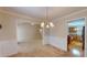 Cozy dining area with a chandelier and wainscoting, seamlessly connected to the living room at 2010 Hickory Station Cir, Snellville, GA 30078