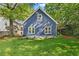 View of the backyard with green lawn, lush trees, flowers, and a blue home exterior at 2089 College Ne Ave, Atlanta, GA 30317