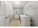Bright laundry room with washer, dryer, tile flooring, and door to the outside at 2089 College Ne Ave, Atlanta, GA 30317