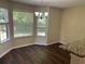 Bright dining area with a chandelier, multiple windows, and stylish, dark wood flooring at 3827 Micah Ln, Ellenwood, GA 30294