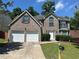 Charming two-story brick home with an attached two-car garage and manicured landscaping at 3827 Micah Ln, Ellenwood, GA 30294