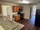 Modern kitchen featuring granite countertops, wood cabinets, and open access to the dining area at 3827 Micah Ln, Ellenwood, GA 30294