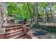 Multi-level backyard with brick patio, outdoor seating, mature trees, and playground for a fun and relaxing atmosphere at 3231 Connemara Trce, Lawrenceville, GA 30044