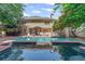 Spacious backyard with a sparkling pool, brick patio, lush landscaping, and outdoor seating for ultimate relaxation at 3231 Connemara Trce, Lawrenceville, GA 30044