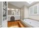 Bright bathroom features a soaking tub with jets, vanity area, and a skylight, creating a relaxing space at 3231 Connemara Trce, Lawrenceville, GA 30044