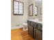 Chic powder room with a decorative wrought iron window, a dark vanity, and hardwood flooring at 3231 Connemara Trce, Lawrenceville, GA 30044