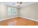 Empty room with hardwood floors, a large window with shutters, and a classic trim at 3231 Connemara Trce, Lawrenceville, GA 30044