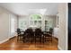 Formal dining room featuring shuttered windows, a glass-top table, and hardwood floors, flooded with natural light at 3231 Connemara Trce, Lawrenceville, GA 30044