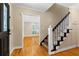 Elegant foyer featuring hardwood floors, a staircase with decorative balusters, and a view into the living room at 3231 Connemara Trce, Lawrenceville, GA 30044