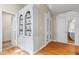 Hallway featuring beautiful hardwood floors, a built-in bookshelf cabinet, and doors leading to other rooms at 3231 Connemara Trce, Lawrenceville, GA 30044