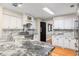 Open kitchen with marble countertops, stainless steel appliances, and white cabinetry at 3231 Connemara Trce, Lawrenceville, GA 30044