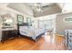 A serene main bedroom with a tray ceiling, a bay window, and hardwood floors that exude sophistication and comfort at 3231 Connemara Trce, Lawrenceville, GA 30044