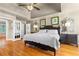 A stylish main bedroom featuring a decorative ceiling, a large bed, hardwood floors, and abundant natural light at 3231 Connemara Trce, Lawrenceville, GA 30044