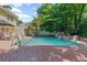 Inviting in-ground pool featuring a brick patio, mature landscaping, and charming water features for ultimate relaxation at 3231 Connemara Trce, Lawrenceville, GA 30044