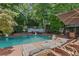 An inviting swimming pool surrounded by lounge chairs, umbrellas, and lush greenery at 3231 Connemara Trce, Lawrenceville, GA 30044