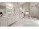Bright bathroom with marble floors, walk-in shower, and dual vanities at 3894 Land O Lakes Ne Dr, Atlanta, GA 30342