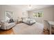 Cozy bedroom featuring plush seating, neutral tones, and ample natural light from two windows at 3894 Land O Lakes Ne Dr, Atlanta, GA 30342