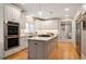 Modern kitchen with white cabinets, marble countertops, stainless steel appliances, and center island at 3894 Land O Lakes Ne Dr, Atlanta, GA 30342