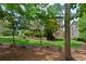 Green backyard featuring a treeline and manicured lawn at 7047 Bennington Ln, Cumming, GA 30041