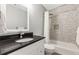 Bathroom featuring a bathtub with shower, black countertop, and white cabinets at 7047 Bennington Ln, Cumming, GA 30041