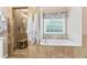 Gorgeous bathroom showcasing a shower, a tub, and a window at 7047 Bennington Ln, Cumming, GA 30041