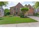 Beautiful two-story brick home with manicured lawn and attached two-car garage at 7047 Bennington Ln, Cumming, GA 30041