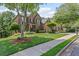 Charming two-story brick home with lush front lawn and mature trees on quiet street at 7047 Bennington Ln, Cumming, GA 30041