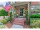 Inviting front porch with brick steps, elegant columns, and a decorative wreath on the front door at 7047 Bennington Ln, Cumming, GA 30041