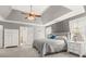Spacious main bedroom featuring a tray ceiling, ceiling fan, and ensuite bathroom at 7047 Bennington Ln, Cumming, GA 30041