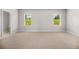 Large bedroom with neutral walls and carpet with views from two large windows at 18 Dorothy Ln, Lawrenceville, GA 30046