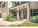 Charming front entrance with brick accents, a black front door, and blooming blue hydrangea bushes at 18 Dorothy Ln, Lawrenceville, GA 30046