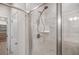 Modern tiled shower with glass door, sleek shower head, and convenient built-in shelving at 18 Dorothy Ln, Lawrenceville, GA 30046