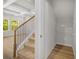 Carpeted stairway with metal balusters leads to a light filled room with many windows and a small closet space at 18 Dorothy Ln, Lawrenceville, GA 30046