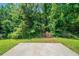 A home's backyard with a concrete patio and forest views at 3283 Sugar Creek Falls Se Ave, Atlanta, GA 30316