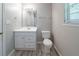 Bathroom featuring a white vanity, framed mirror, toilet, and modern light fixture at 3283 Sugar Creek Falls Se Ave, Atlanta, GA 30316