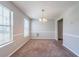 Empty dining room featuring plush carpet, wainscoting, updated paint, and a decorative chandelier at 3283 Sugar Creek Falls Se Ave, Atlanta, GA 30316