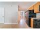Functional kitchen with wooden cabinets and black appliances leading to an adjacent room at 3283 Sugar Creek Falls Se Ave, Atlanta, GA 30316
