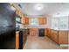 Bright kitchen featuring wood cabinets, black appliances, tile floors, and a view to the backyard at 3283 Sugar Creek Falls Se Ave, Atlanta, GA 30316