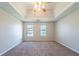 The unfurnished main bedroom features a tray ceiling and neutral carpet at 3283 Sugar Creek Falls Se Ave, Atlanta, GA 30316